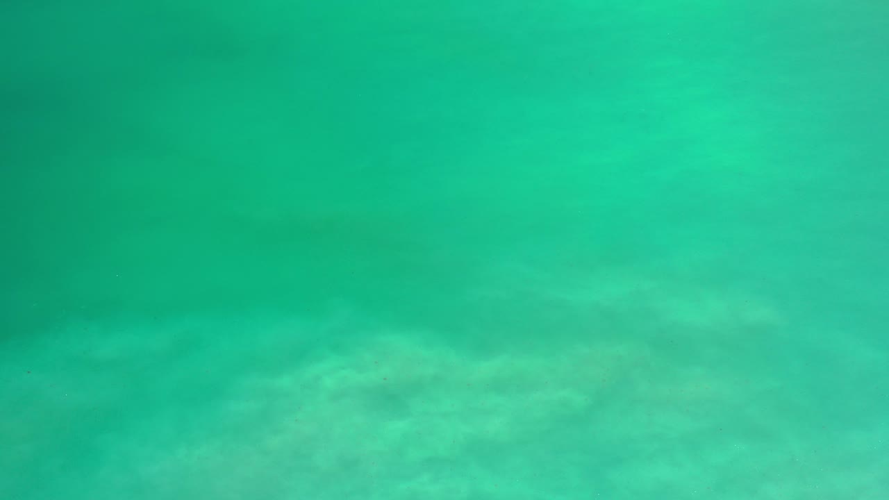 Overhead turquoise ocean with darker underwater patches