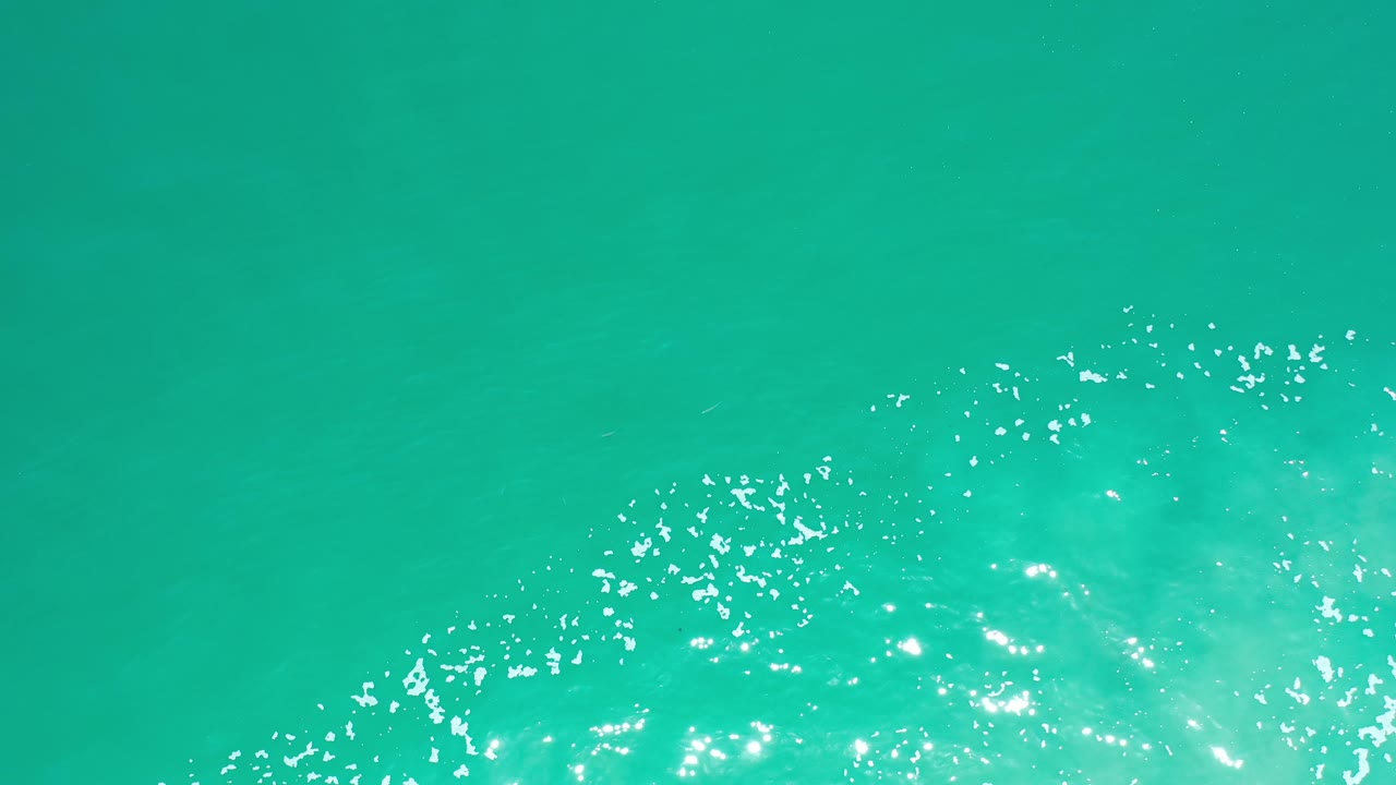 Aerial-style view of turquoise water and white sparkle.