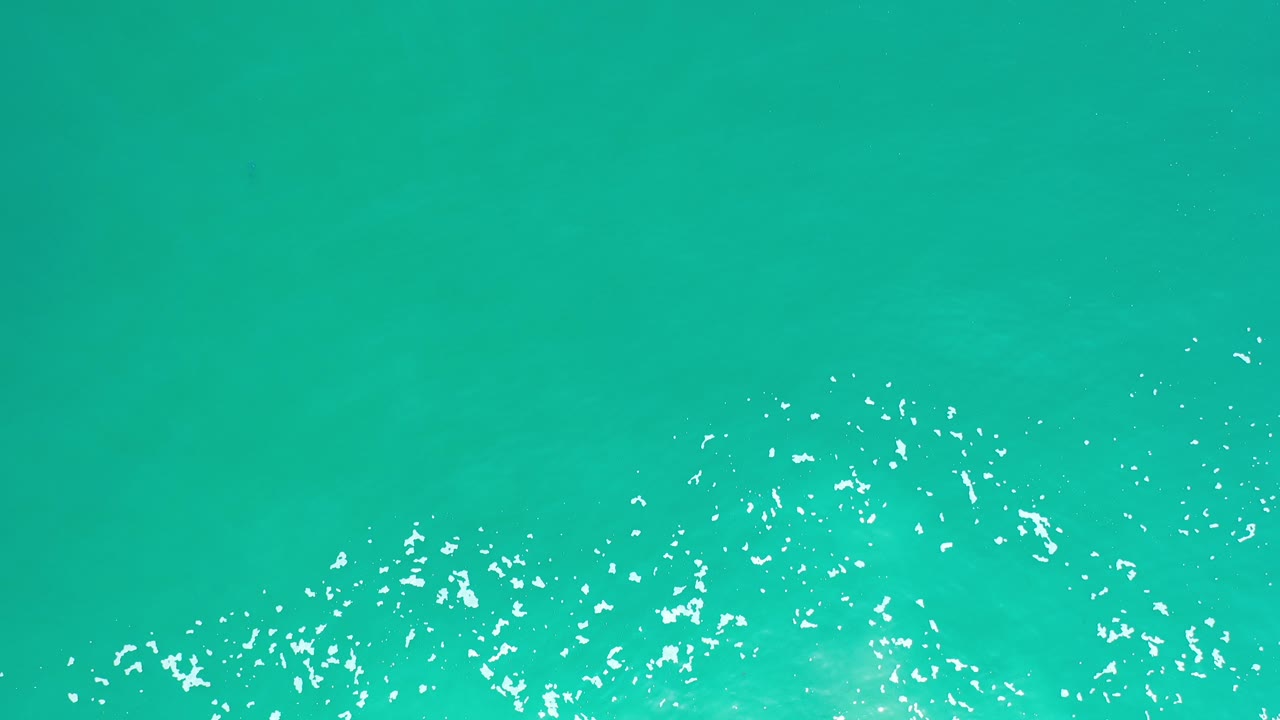Green-turquoise water with bright surface reflections.