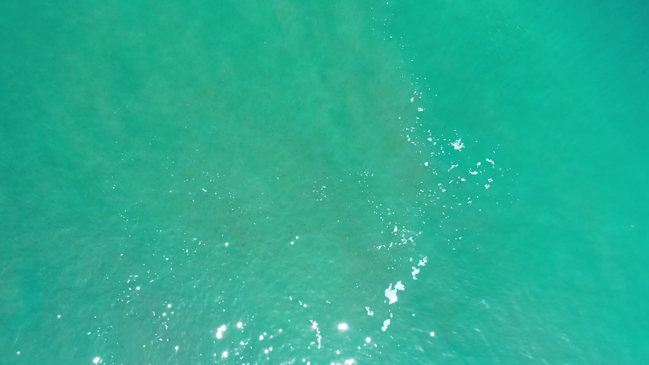 Turquoise water surface with small sunlight glints