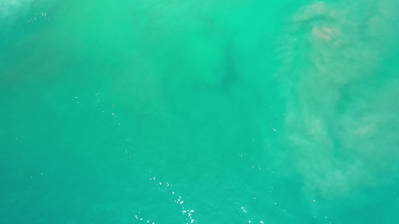 Turquoise water surface with pale underwater swirls