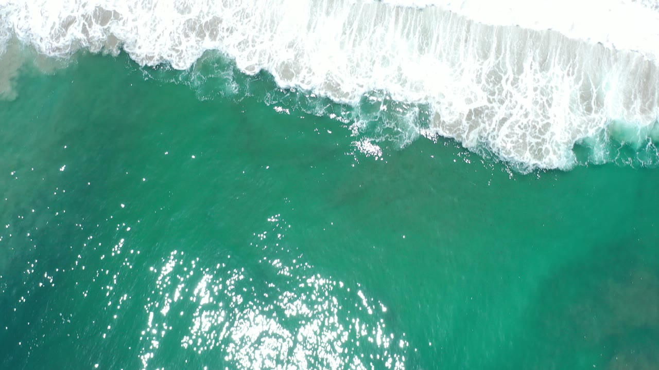 Overhead turquoise ocean with white surf at the top edge.