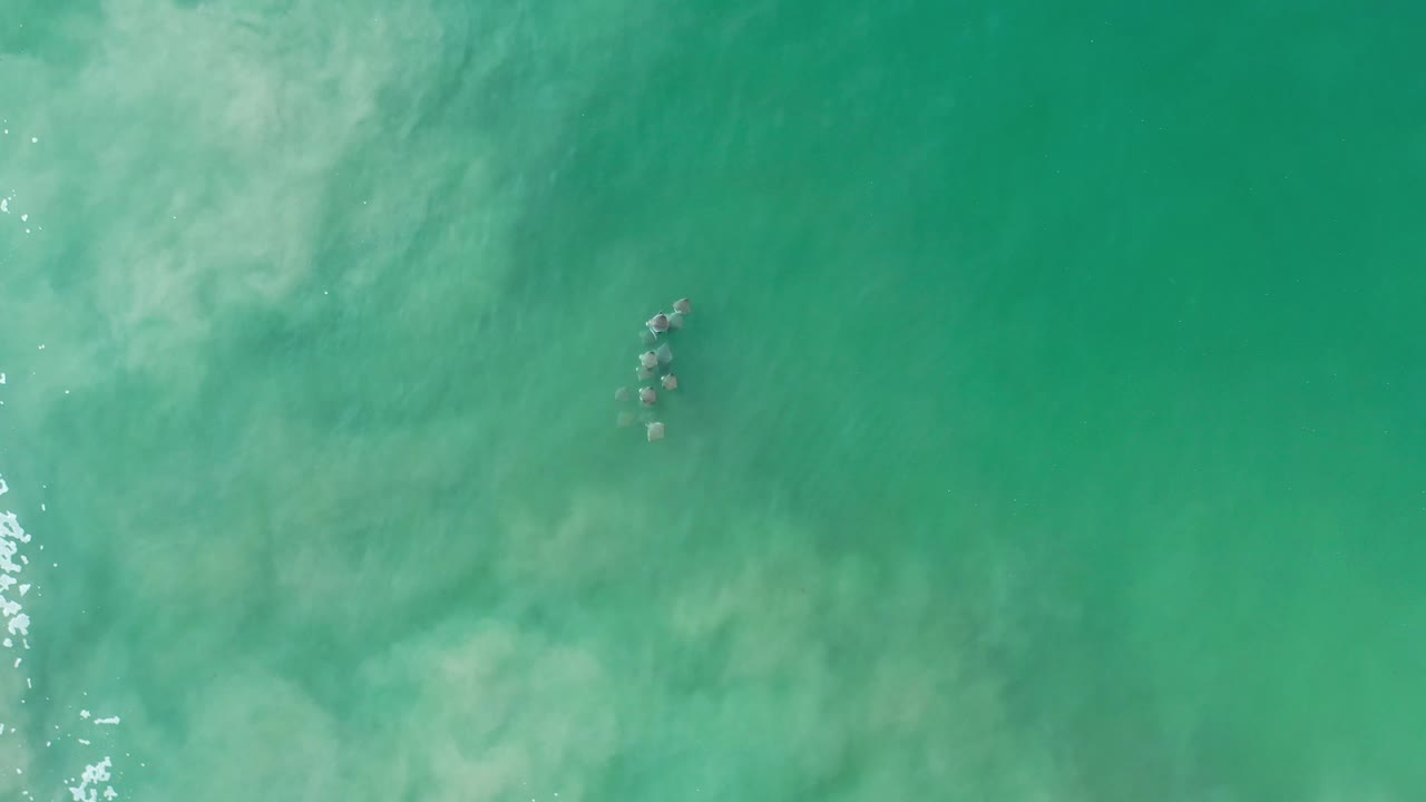 Aerial green water with small rocks near the top.