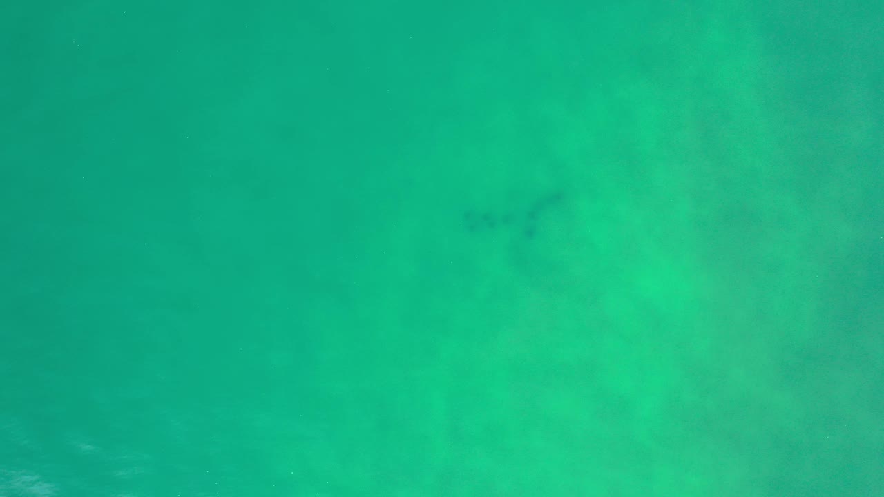 Turquoise ocean water fills the opening frame in Los Cabos, Mexico, with faint pale surface texture and no visible people.