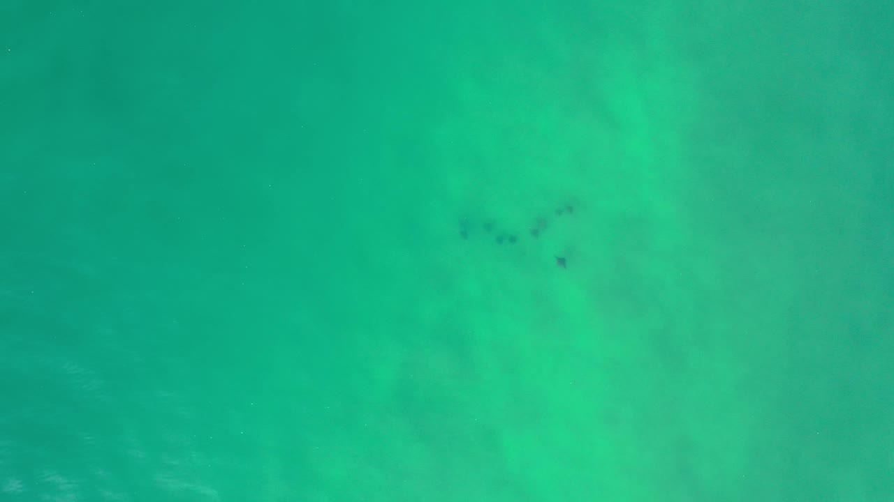 Bright turquoise sea with cloudy underwater patches.