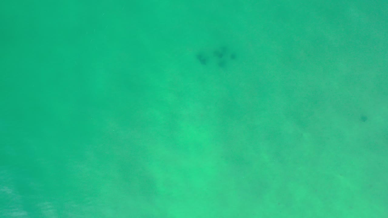 Overhead view of turquoise water in Los Cabos, Mexico, with soft clouded color shifts and no visible people.