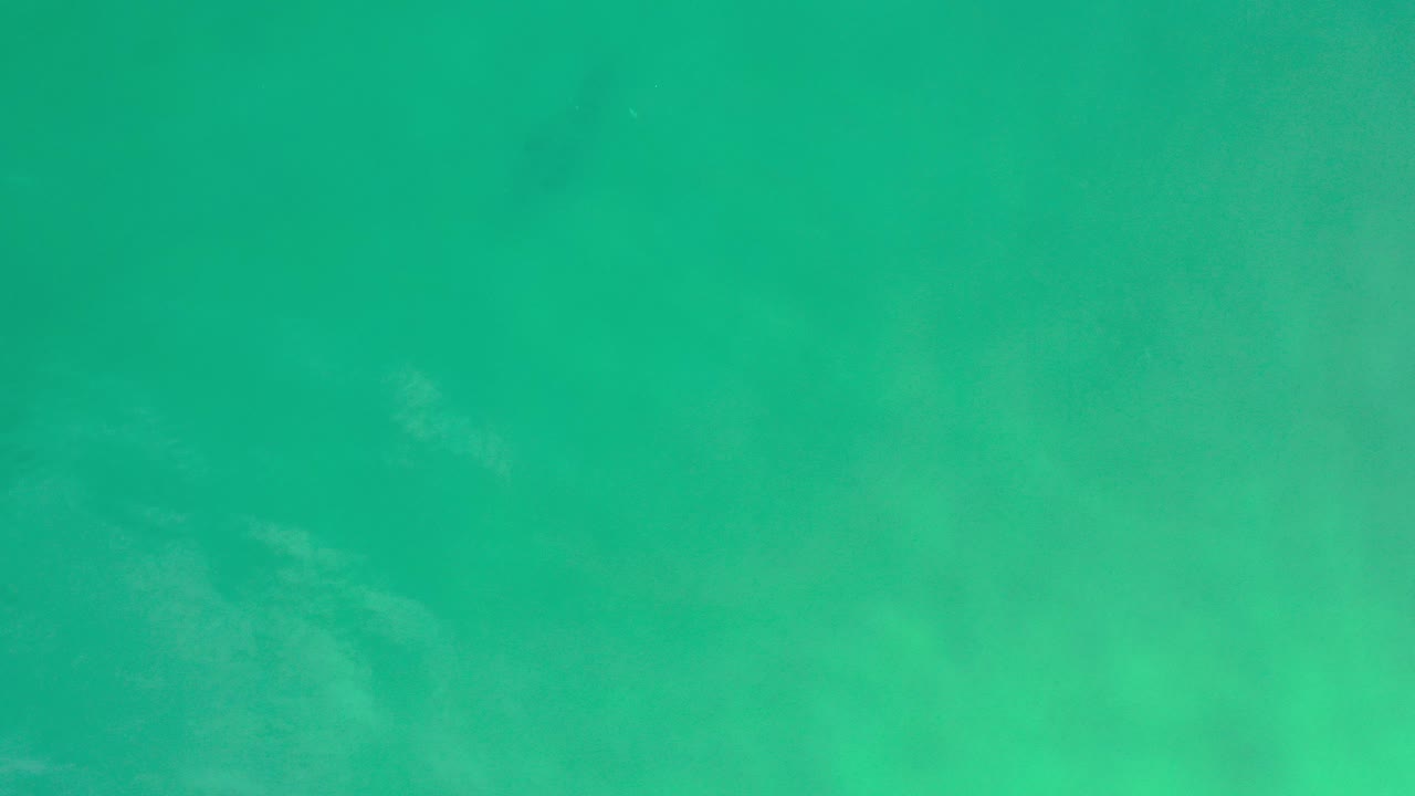 Overhead view of turquoise ocean water in Los Cabos, Mexico, with soft pale patches below the surface and no visible people.
