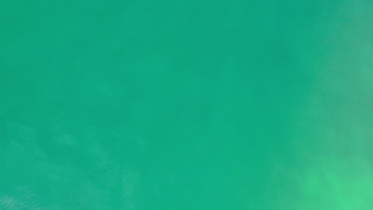 Overhead view of turquoise green sea water in Los Cabos, Mexico, with faint underwater texture and no visible people.