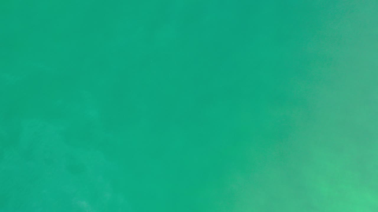 Overhead green water in Los Cabos, Mexico with faint surface ripples and pale underwater texture, no visible people.