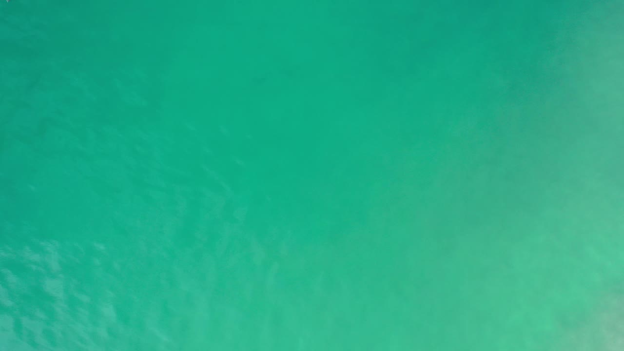 Overhead sea water with broad teal color and lighter patches under the surface.