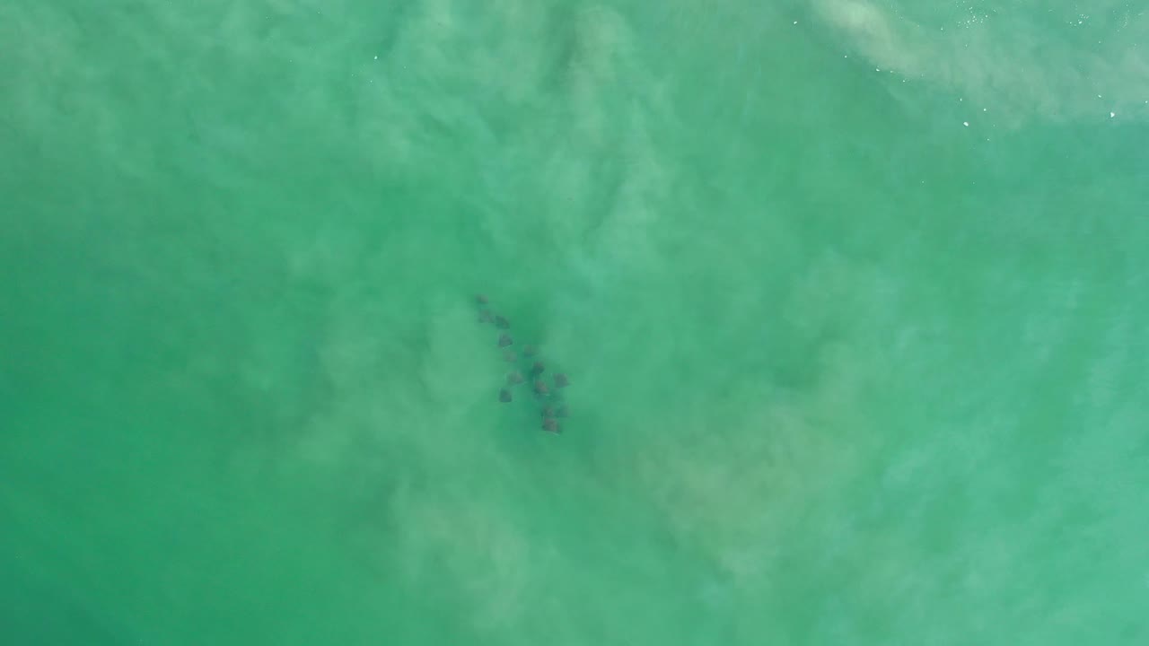Turquoise-green water with a dark cluster in the upper right area.