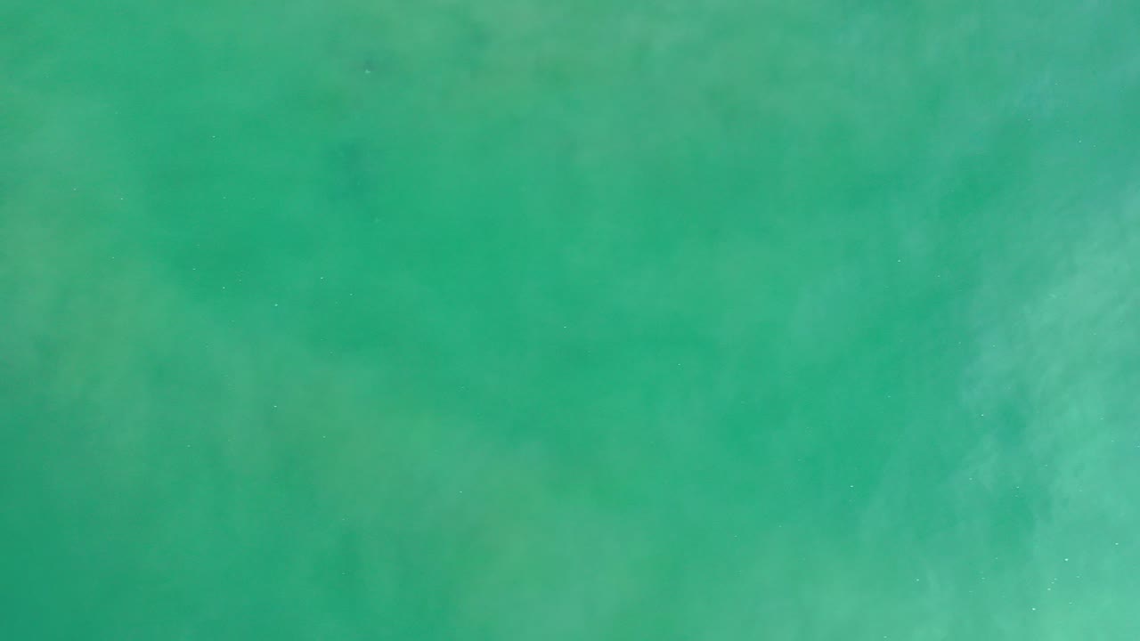 Top-down view of turquoise ocean water in Los Cabos, Mexico, with pale underwater texture and no visible people.