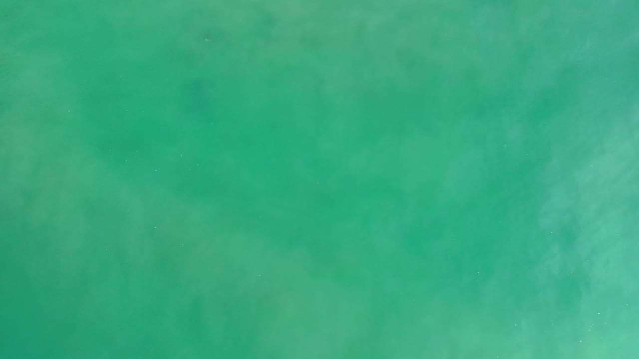Overhead turquoise water in Los Cabos, Mexico, showing subtle pale streaks beneath the surface and no visible people.