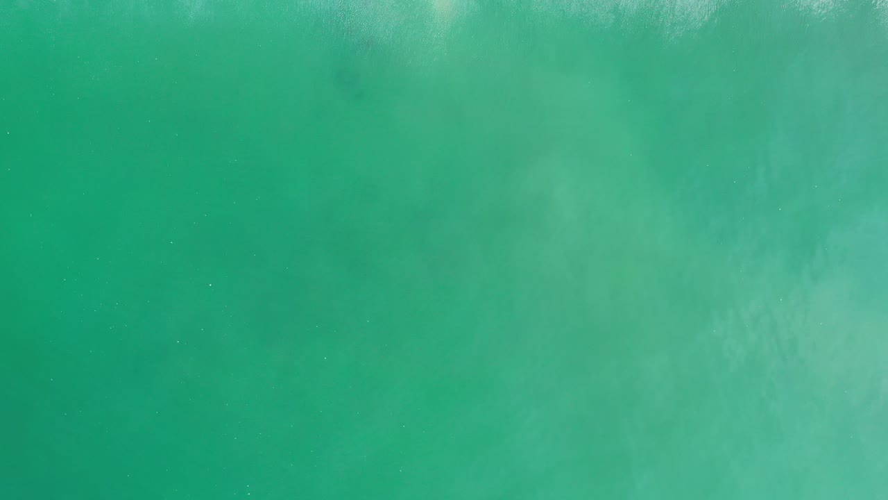 Sea green water fills the first frame from Los Cabos, Mexico, with faint ripples, pale underwater patches, and no visible people.