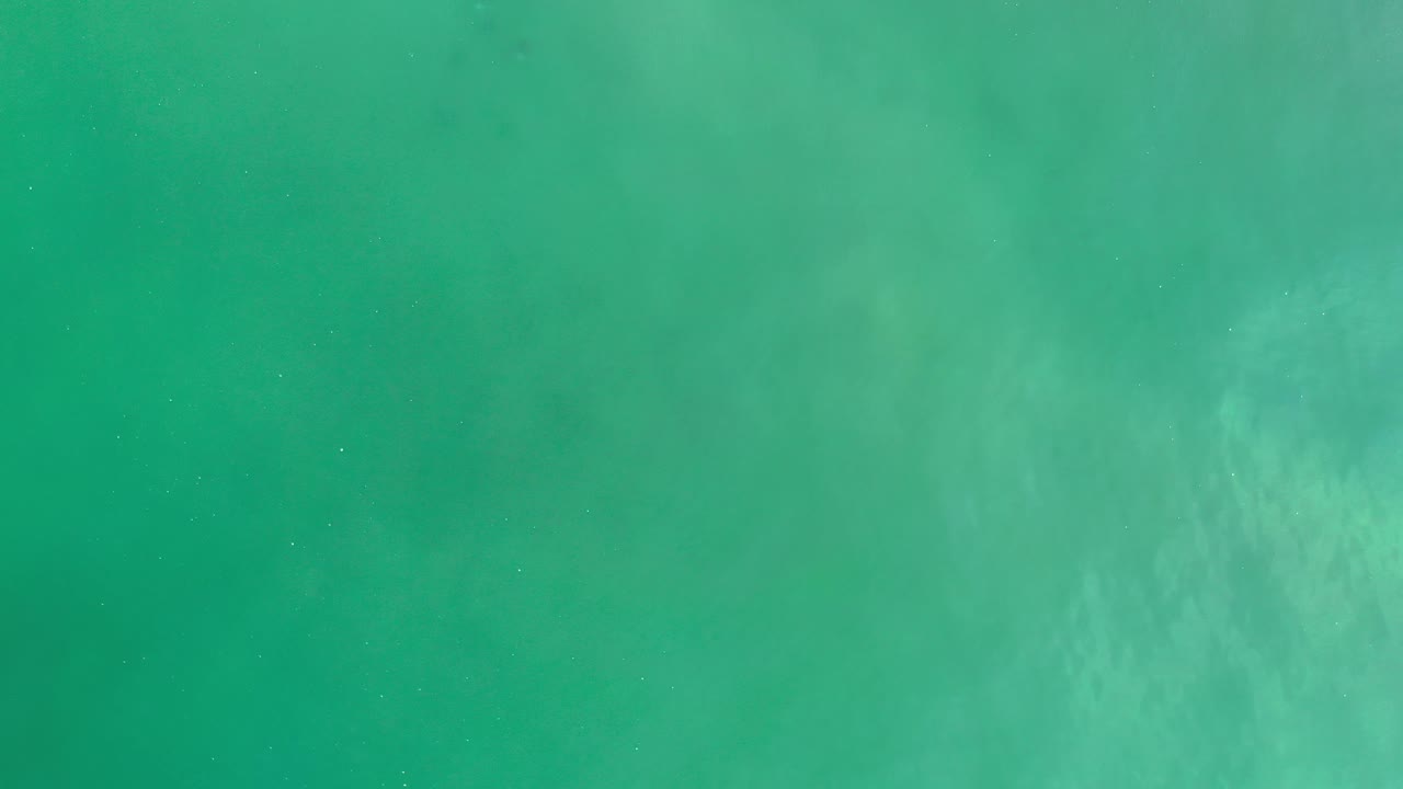 Light sea green water with faint pale swirls.