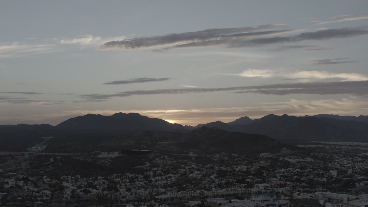Gray clouds over dark mountains and a low town