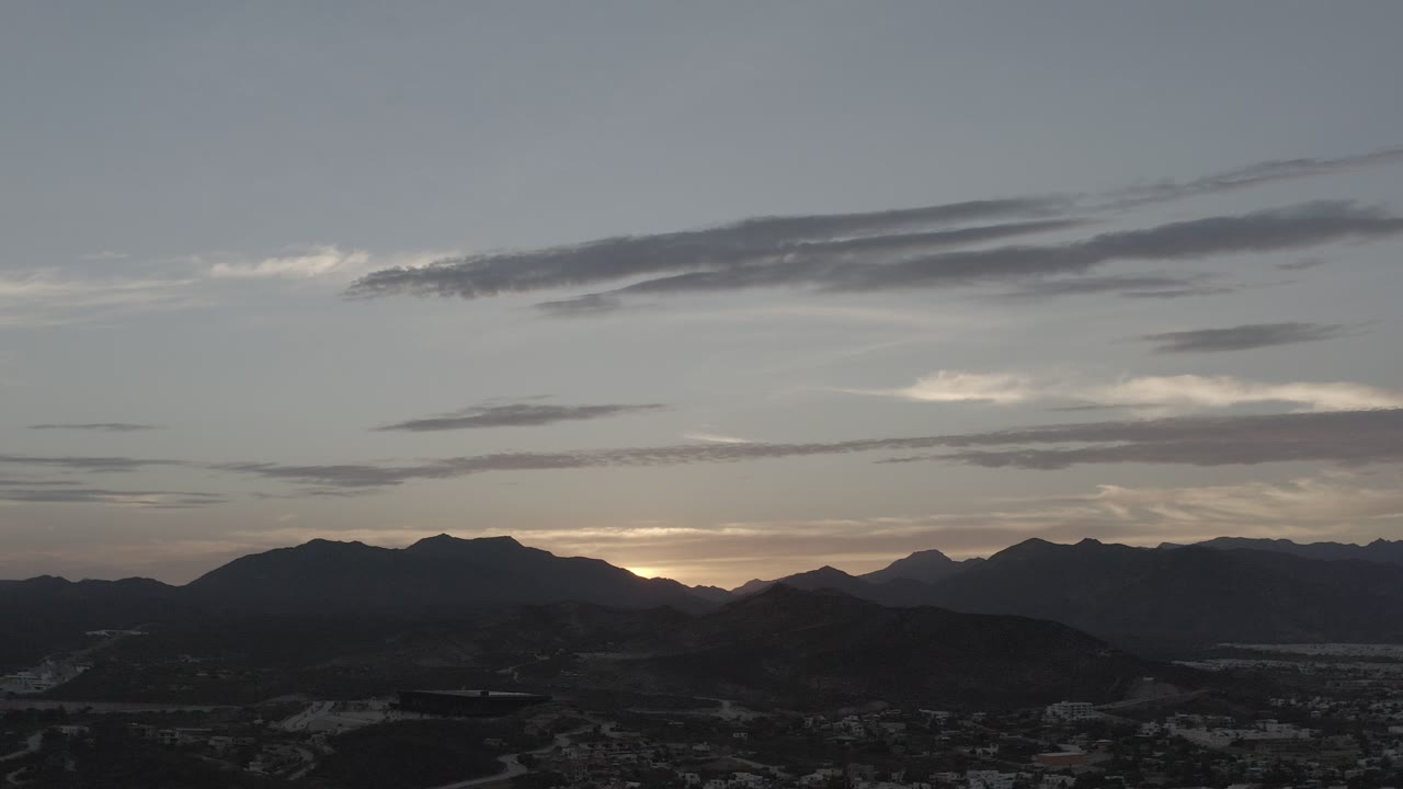 Mountain ridge beneath layered dusk clouds.