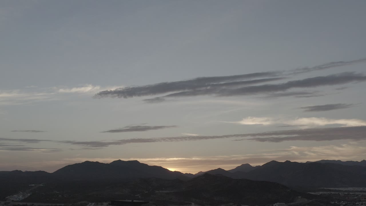 Sunset glow behind layered mountain peaks