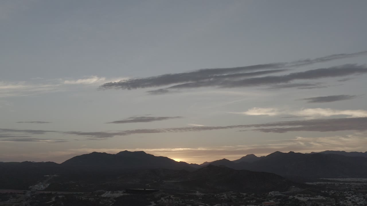 Distant mountains and low sunset light beneath clouds