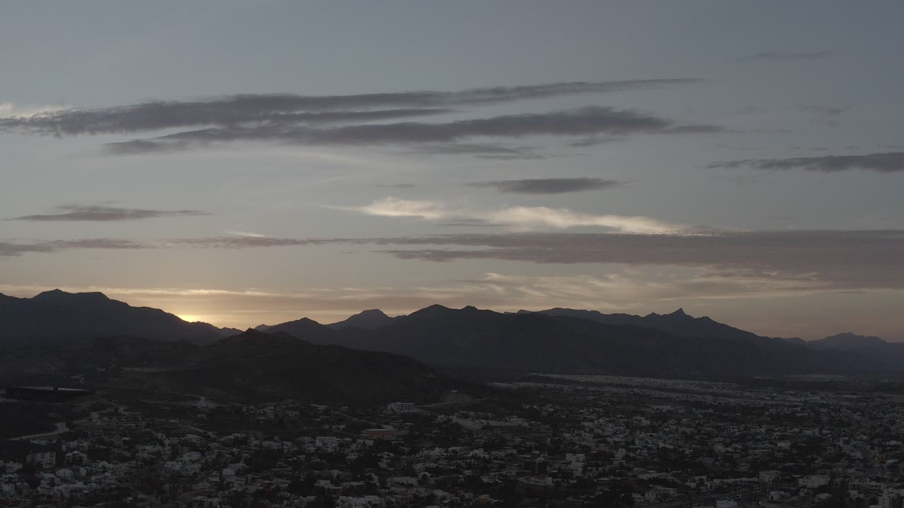 Dusk view of mountains above a dark townscape