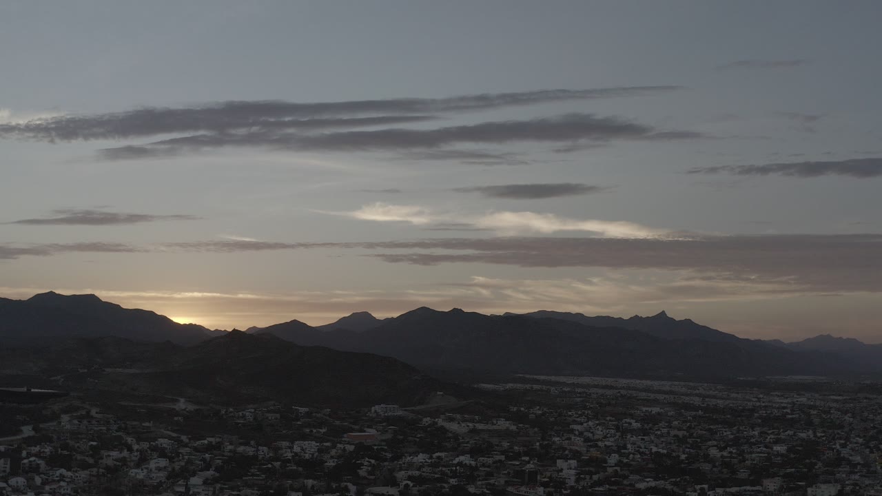 Dim mountain skyline over a town at late afternoon