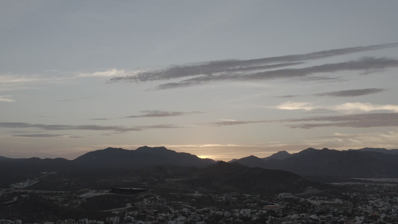 Mountain skyline at dusk above a shadowed city