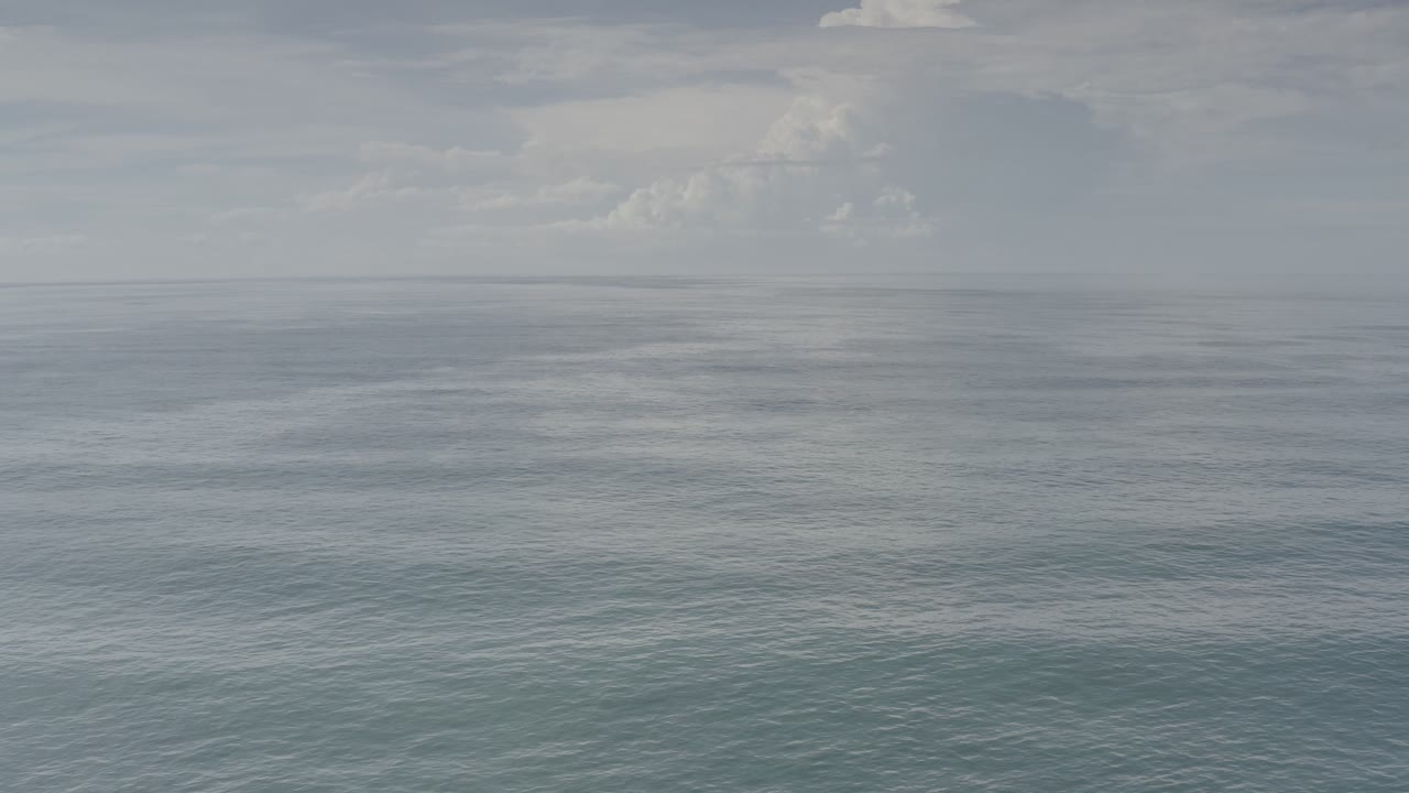 Open sea and distant cloud bank in soft gray light