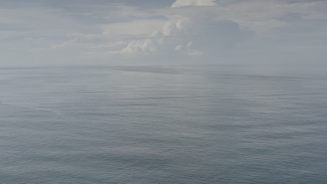 Opening frame of gray-blue ocean off Los Cabos, Mexico, with a low distant horizon, soft clouds above, and no visible people.