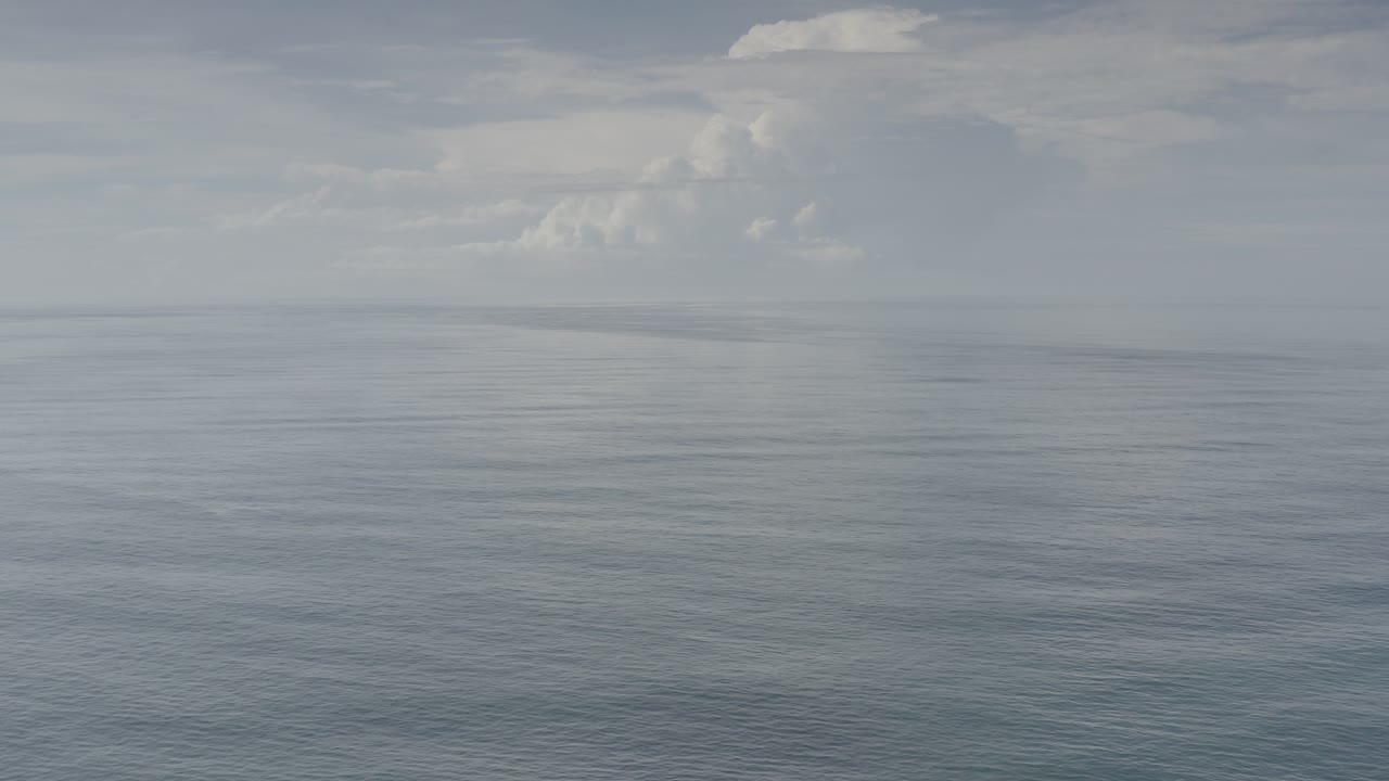 Wide ocean horizon under a cloudy sky