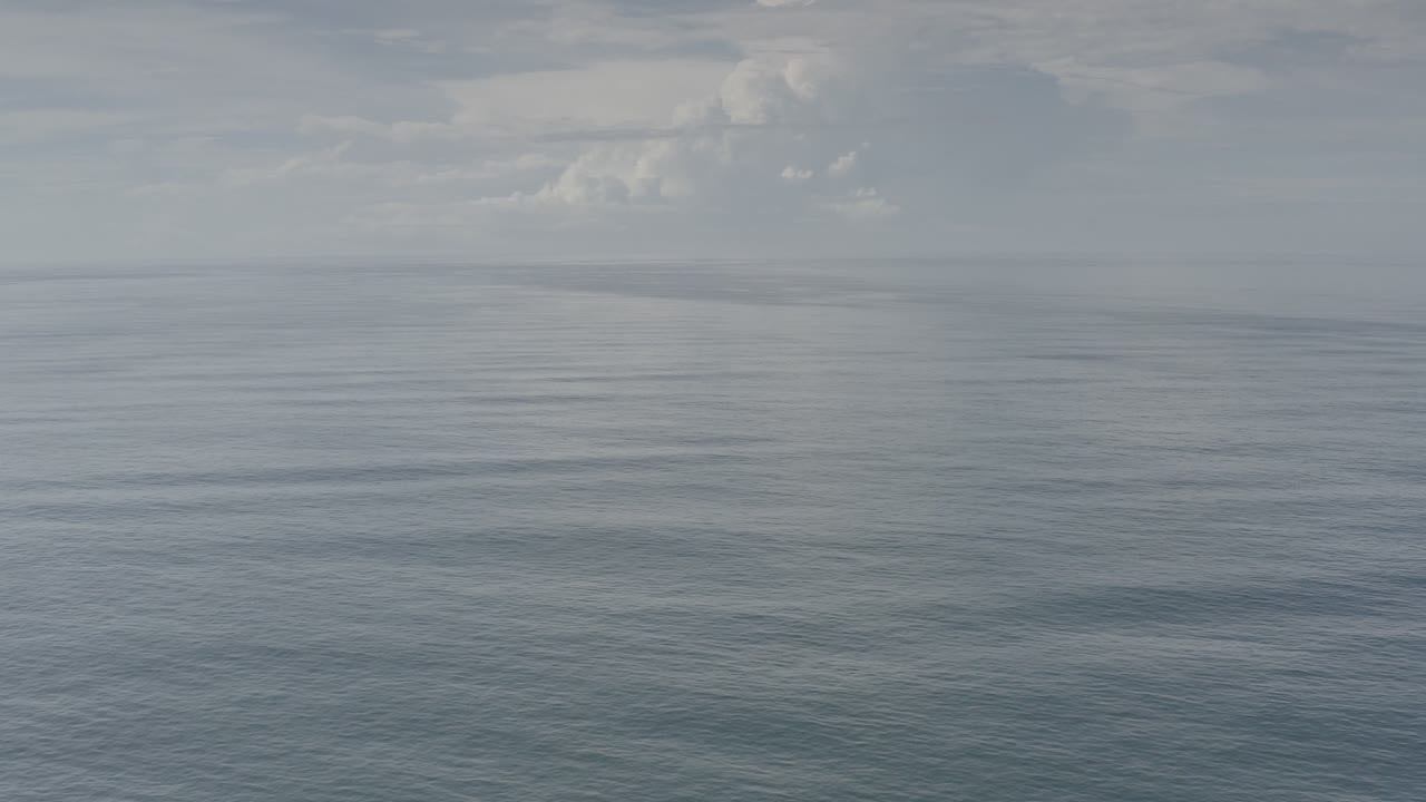 Wide view of gray-blue ocean and a pale clouded sky in Los Cabos, Mexico, with a level horizon and no visible people.