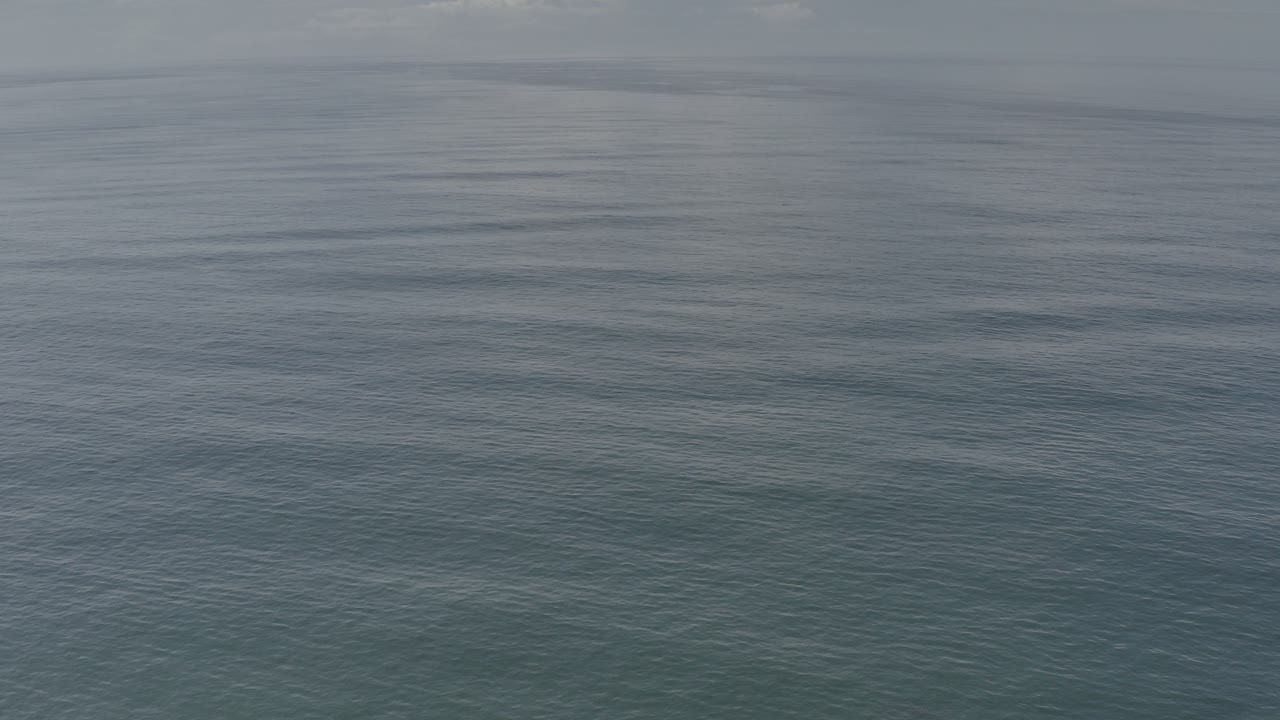 Opening frame of calm blue-green water in Los Cabos, Mexico, with a soft horizon line near the top and no visible people.