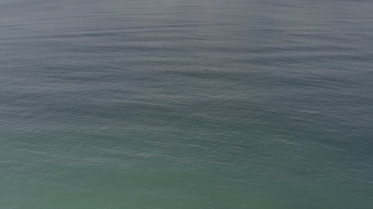At 0:00, rippled sea water in Los Cabos fills the frame with a darker blue-gray band above and green-blue water below, with no visible people.