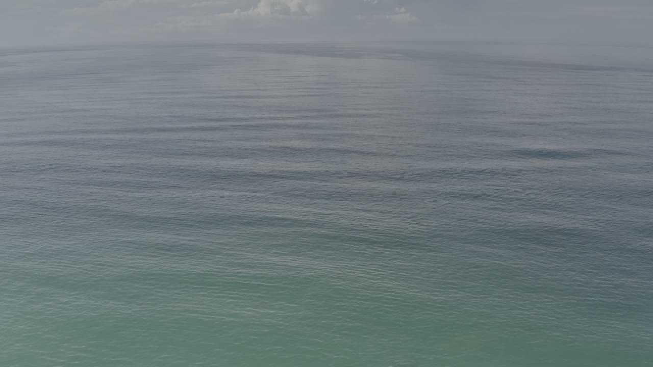 Open water with a gray sky and subtle surface movement.