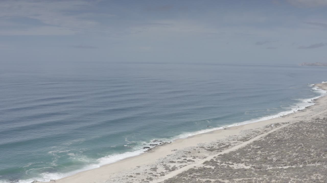 Aerial view of ocean waves reaching a sandy coastline