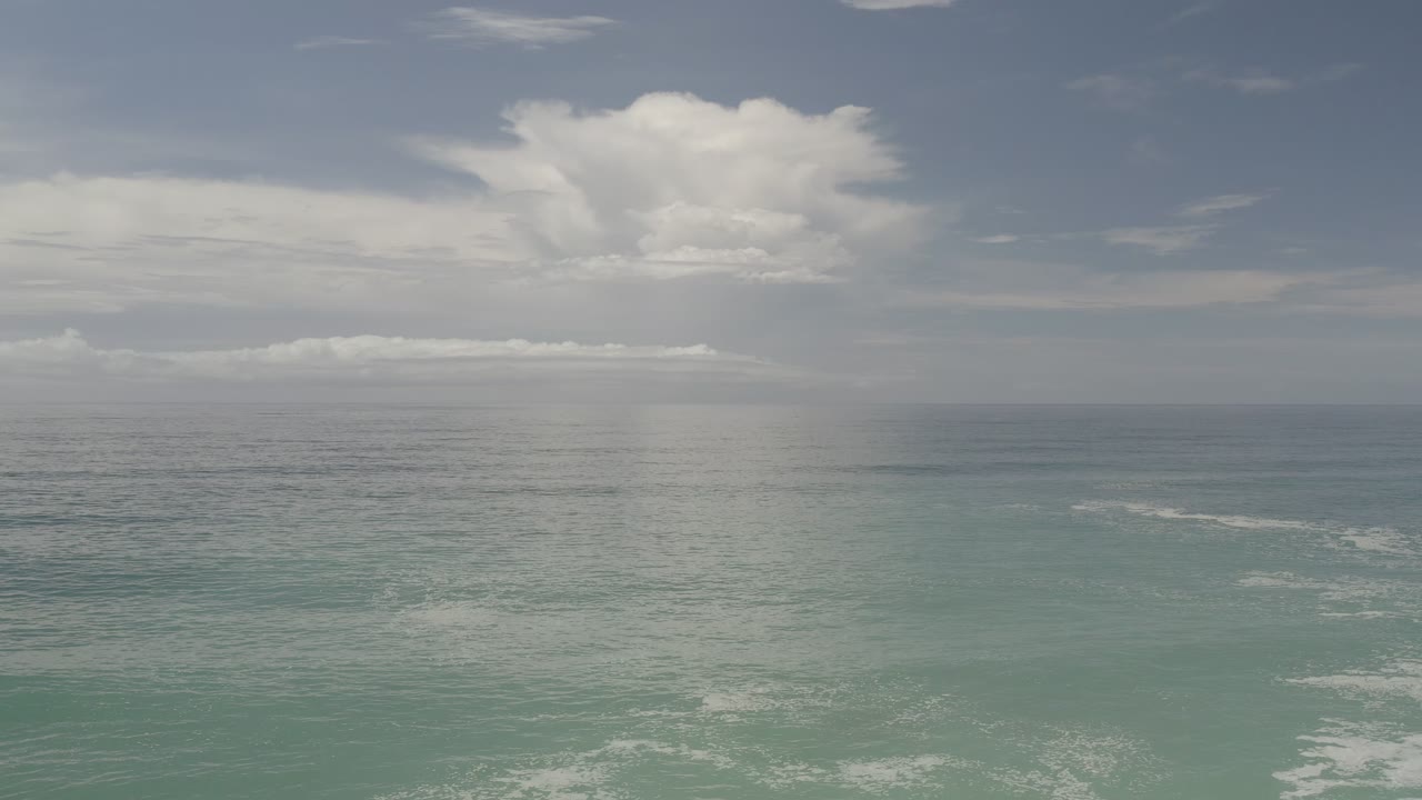 Los Cabos ocean horizon with teal water in the foreground, layered clouds across the sky, and no visible people at 0:00.