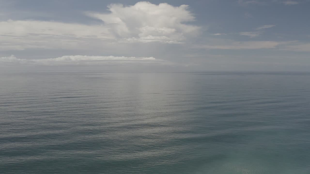 Blue-green sea below a cloudy horizon