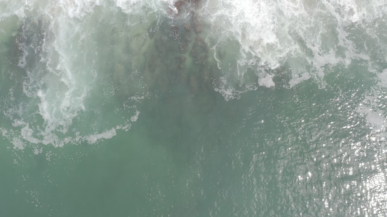 Ocean foam and underwater dark patches seen from above