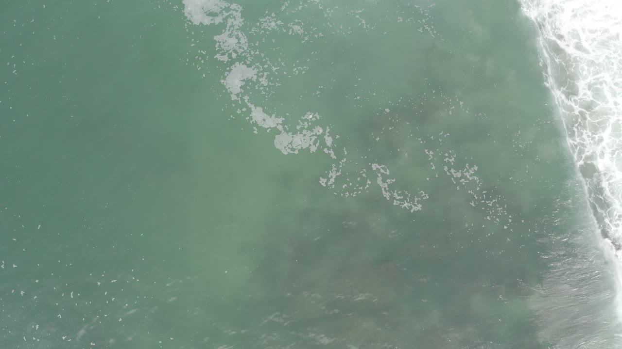 Soft green water with surf foam entering from the right
