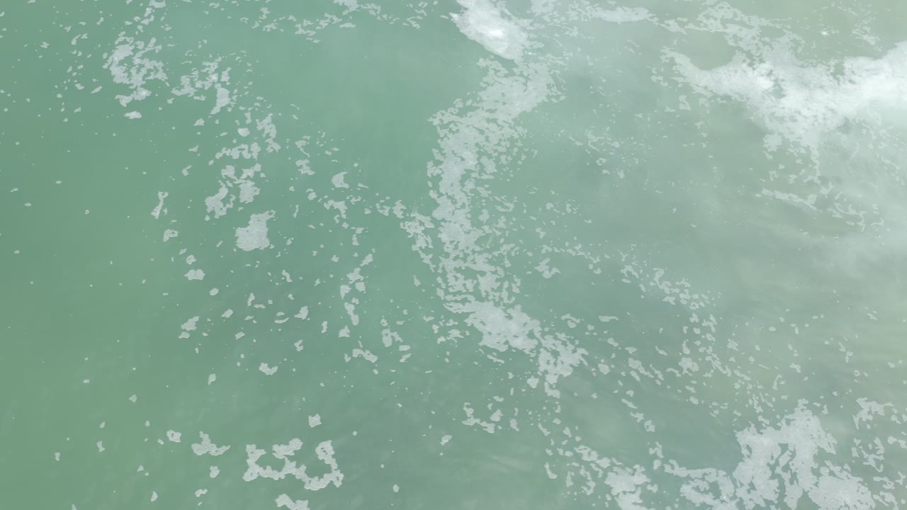 Overhead sea surface with white foam clusters