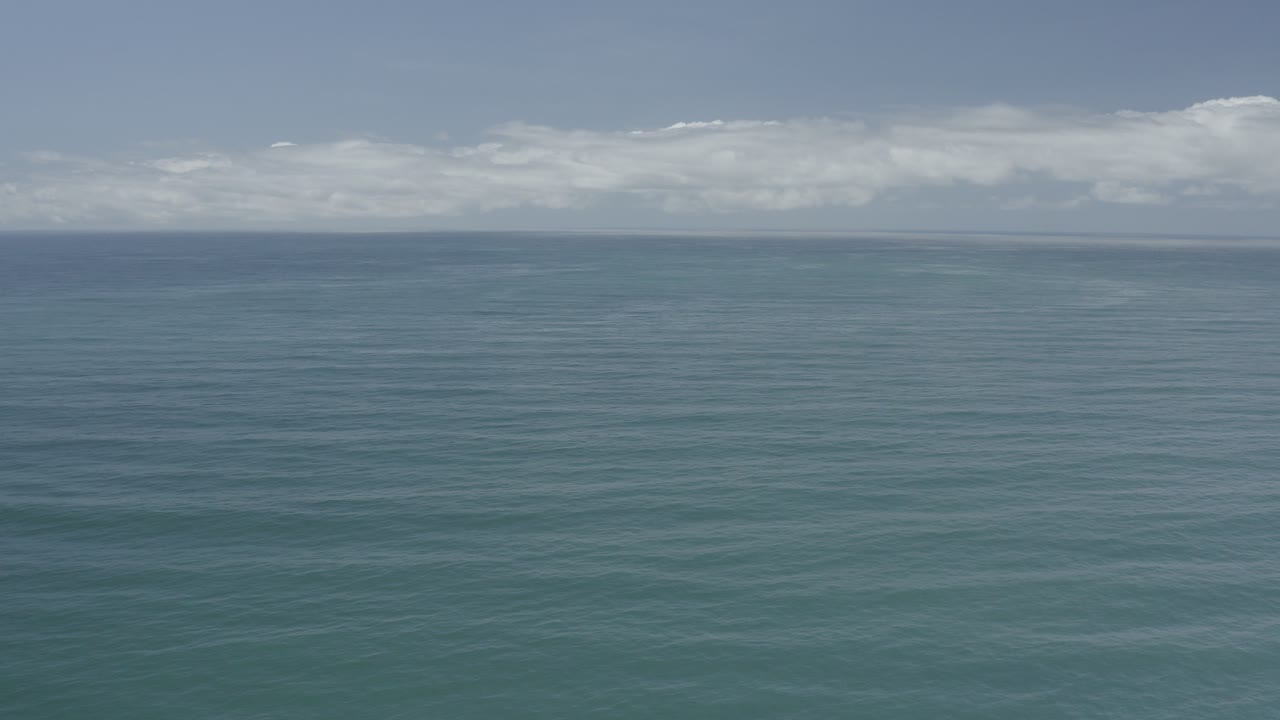 Opening frame of a Los Cabos ocean view with blue-green water, a distant horizon, pale clouds, and no visible people.