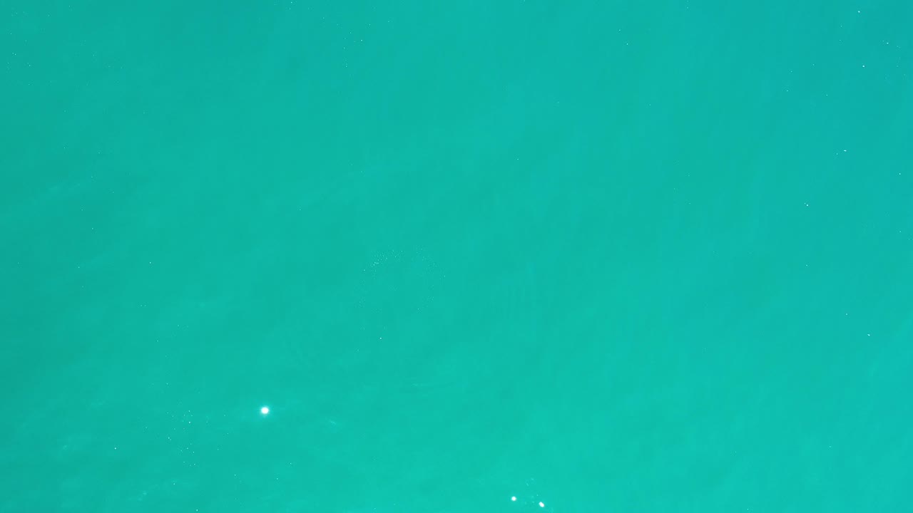 Open turquoise water with sparse white sparkles.