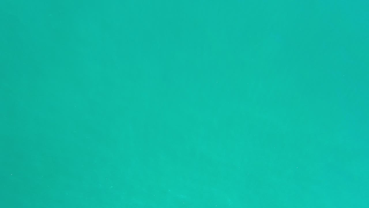 Teal water texture fills the frame in Los Cabos, Mexico, with faint ripple bands and no visible people.