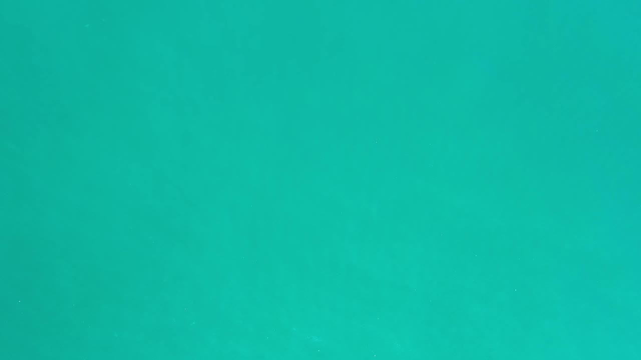 A near-uniform teal water surface in Los Cabos shows gentle wave texture and slight tonal shifts, with no visible people.