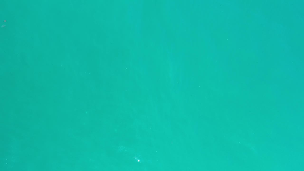 Aerial view of clear turquoise water and small highlights.