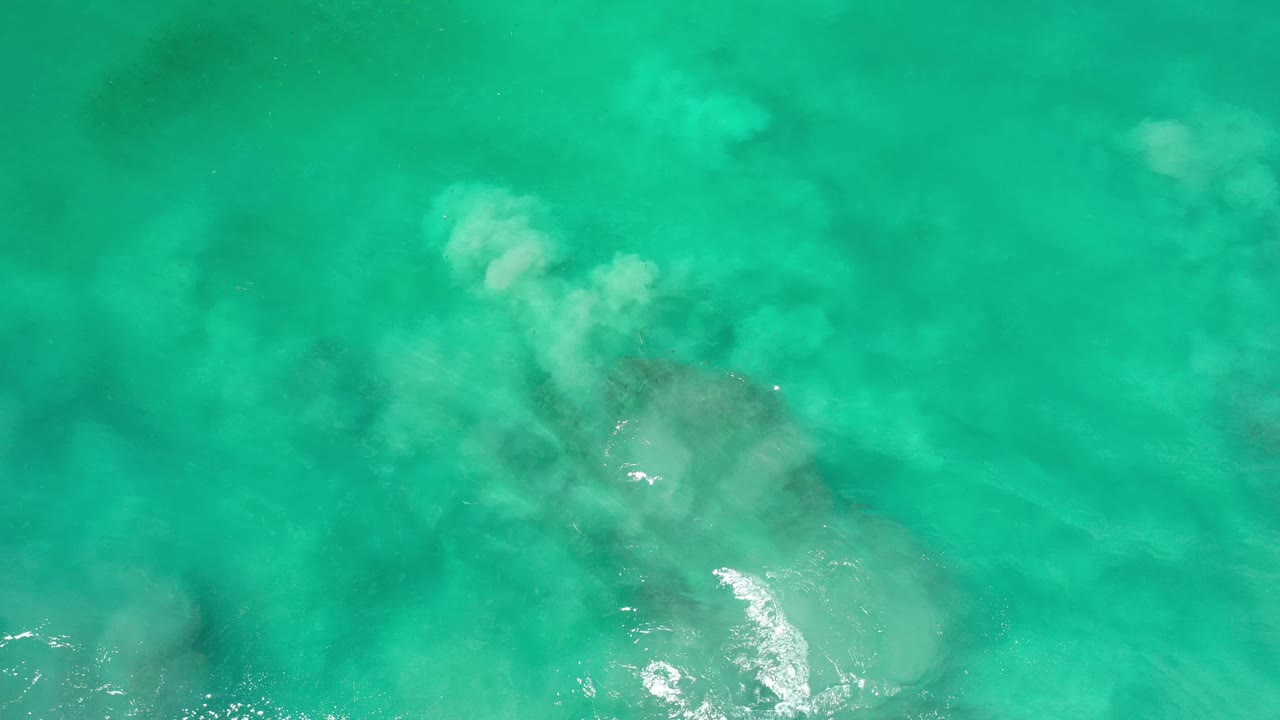 Blue-green Los Cabos ocean water fills the frame, with soft submerged pale patches, a few reflective highlights, faint shadowing below the surface, and no visible people.