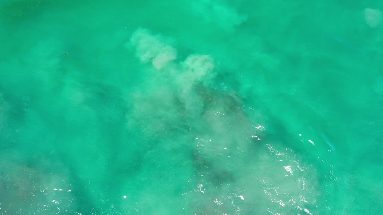 Overhead green ocean water with pale surf over submerged rocks