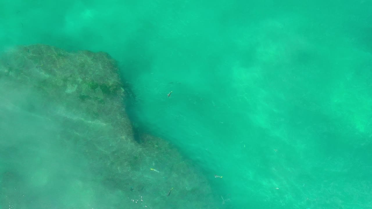 Clear turquoise water with rock edge below