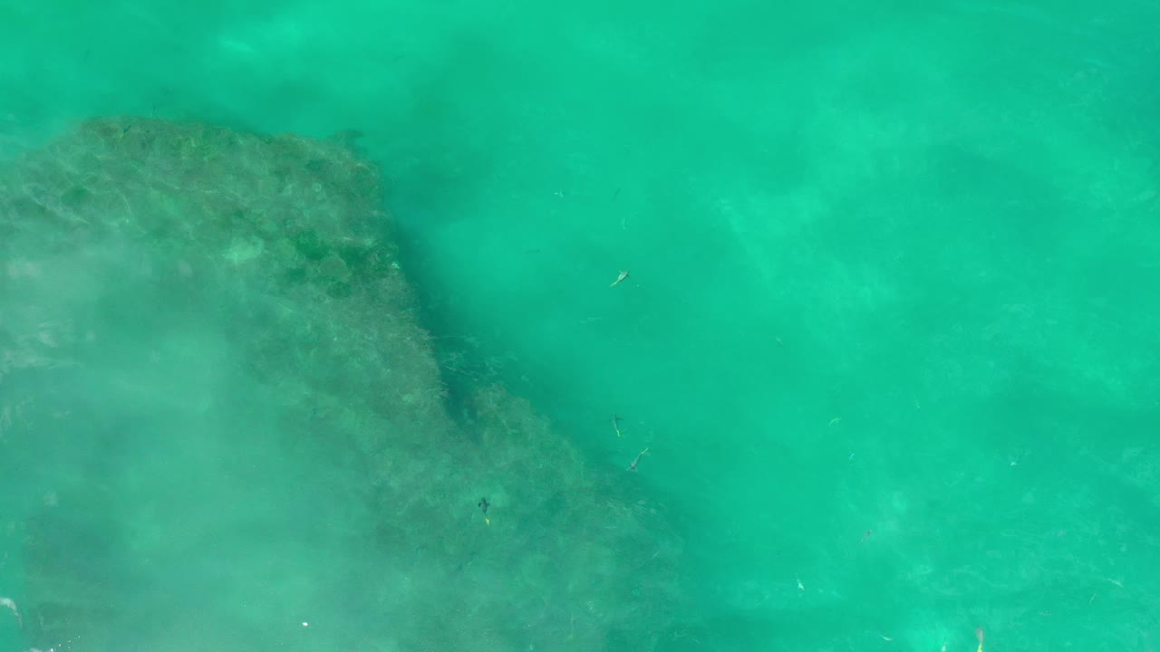 Turquoise water with a darker underwater edge near the upper left.