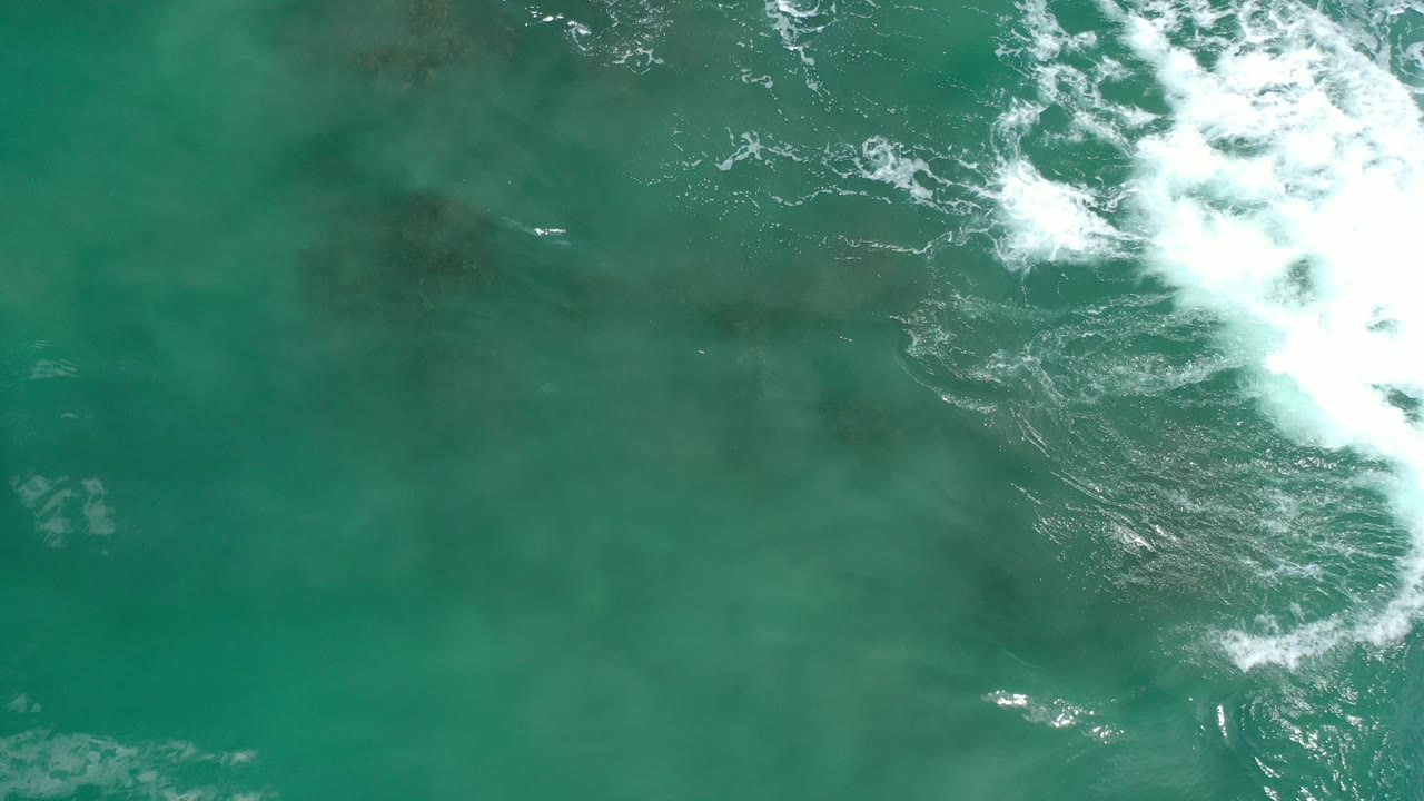 Breaking surf at the upper right above darker reef water