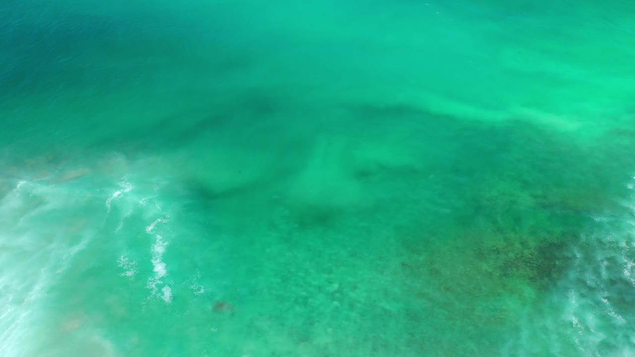 Blue-green underwater ocean in Los Cabos, Mexico with bright ripple lines entering from the lower left and no visible people.